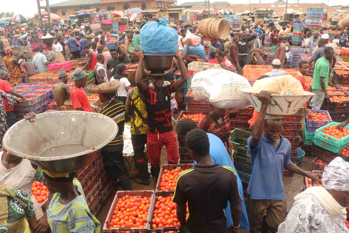 Traders and workers at a Nigerian produce market, illustrating the wider economic conditions discussed in the argument. Credit: El País